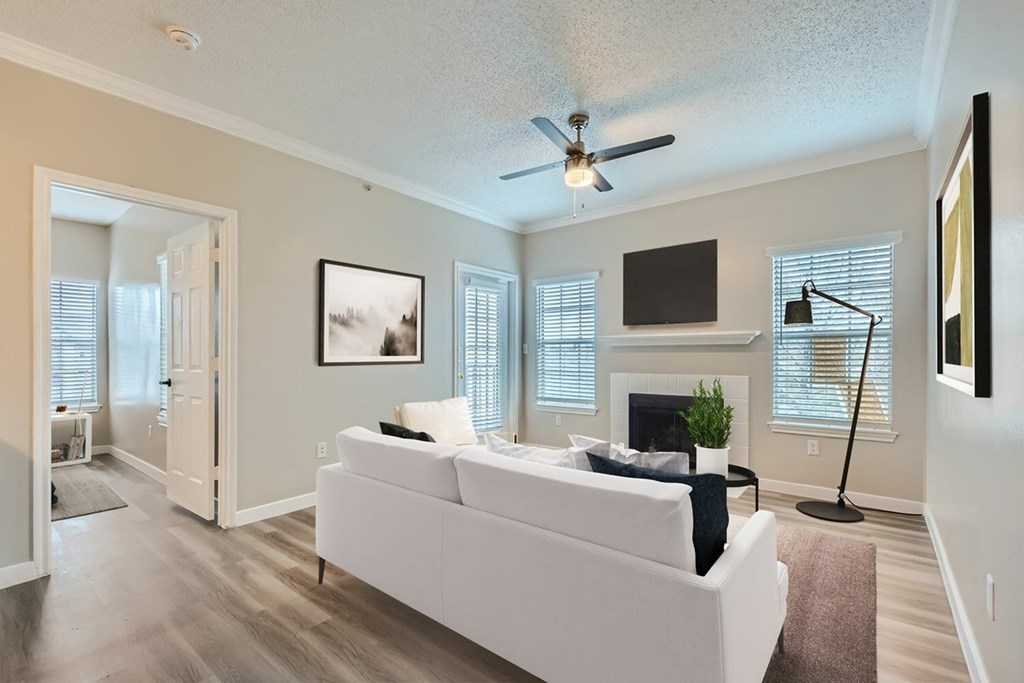 A living room with a white couch and a ceiling fan.