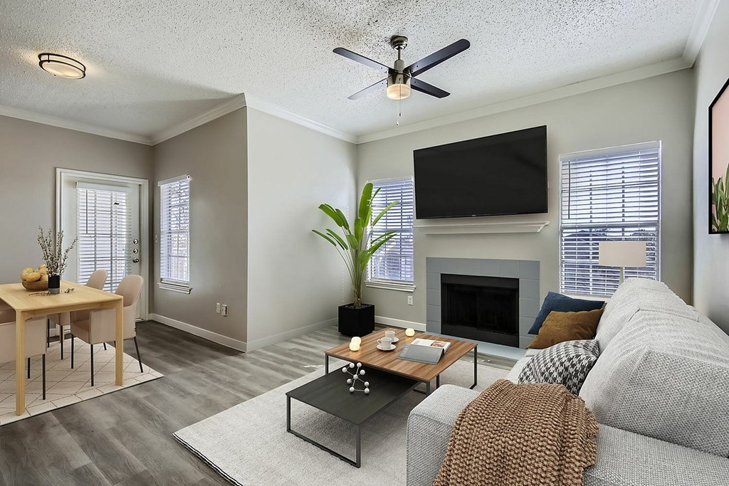 A living room with a grey couch, a fireplace, and a television.