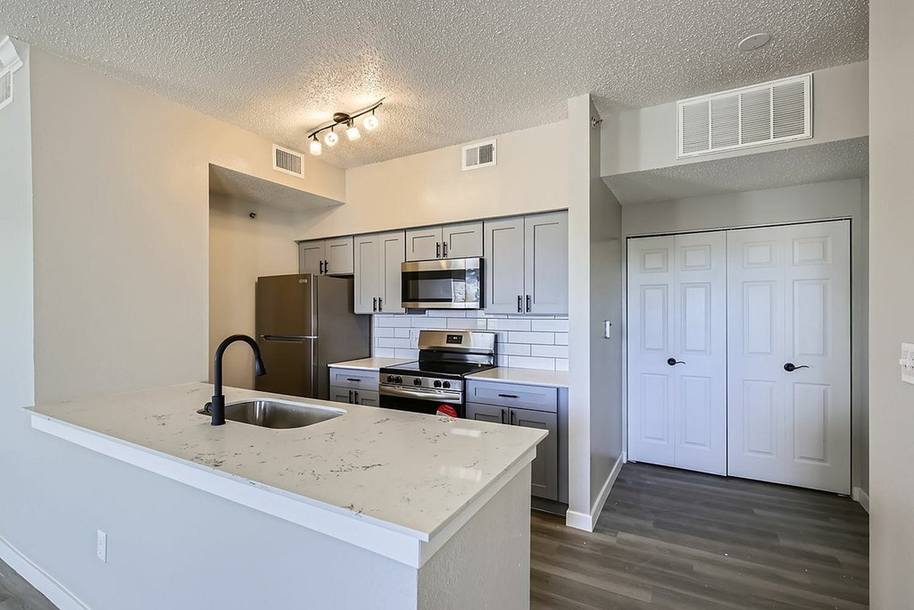 A kitchen with a sink and a refrigerator.