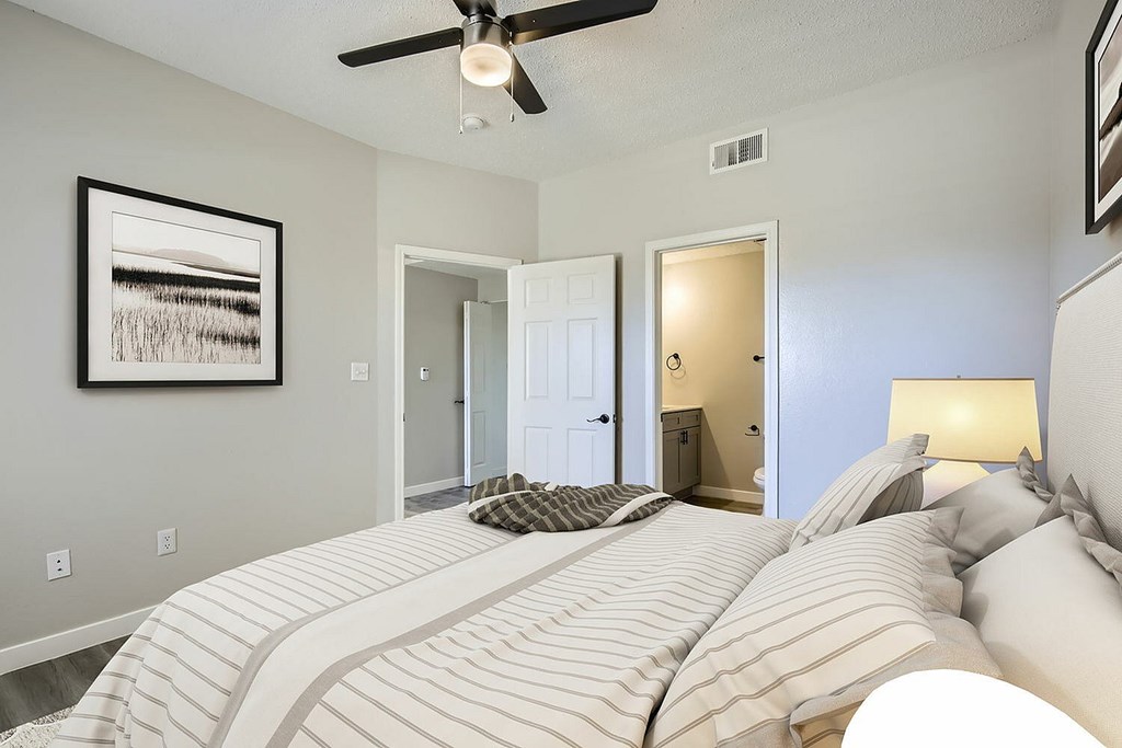 A bedroom with a large bed and a ceiling fan.