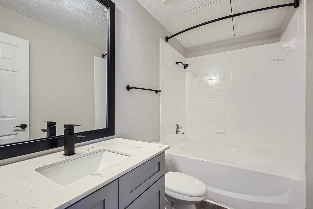 A white bathroom with a sink, toilet, and bathtub.