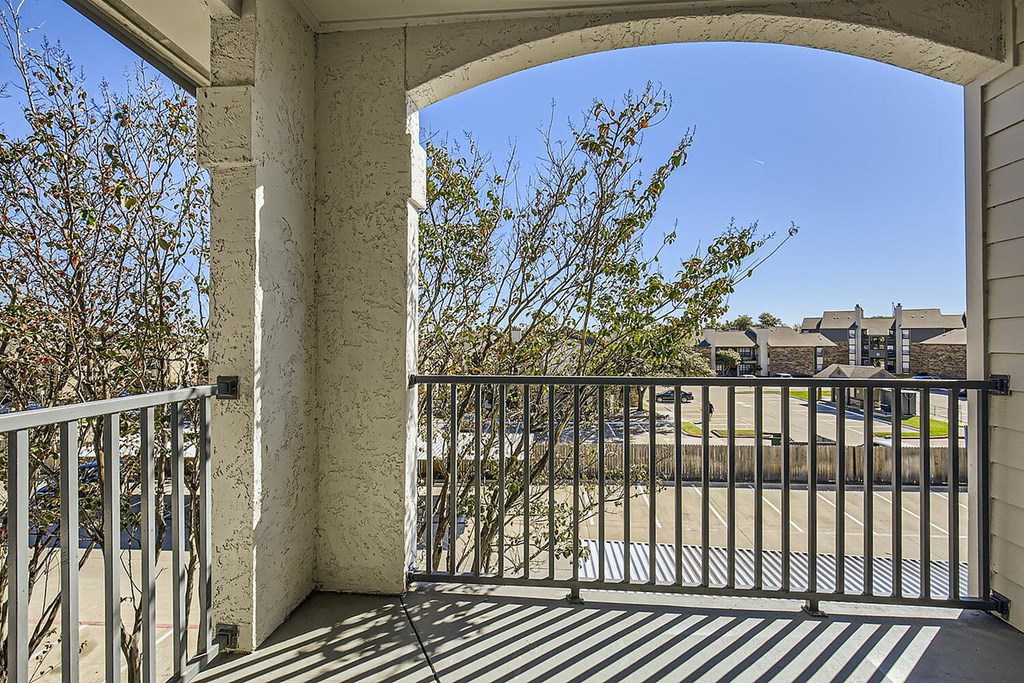 A balcony with a metal railing and a gate.