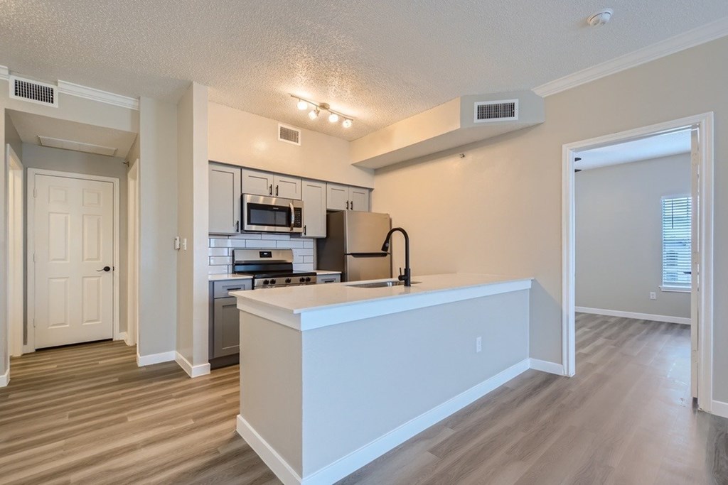 A kitchen with a white island in the middle.