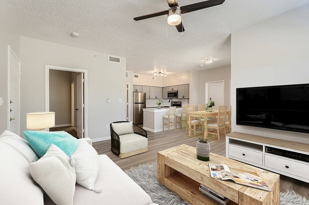 A living room with a white couch and a wooden coffee table.