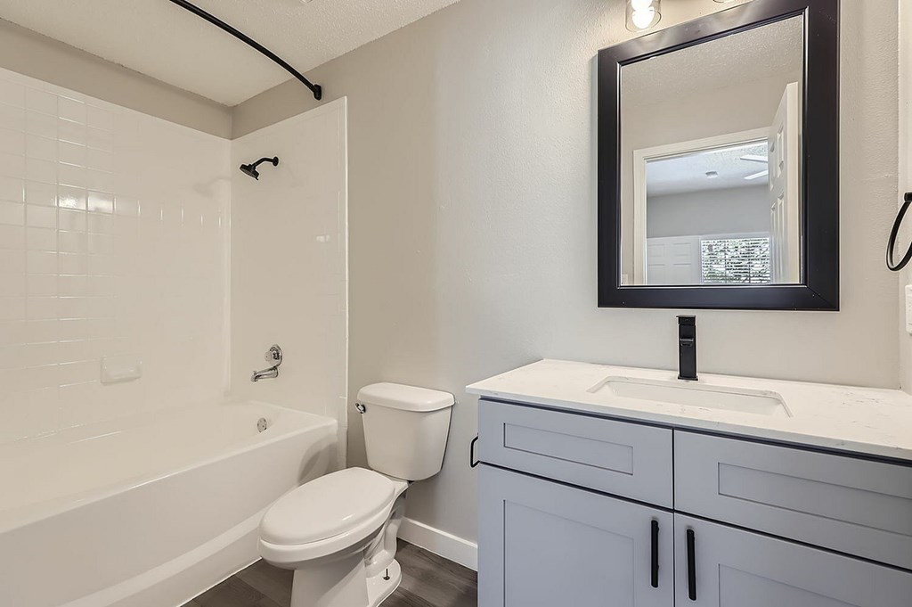 A white toilet sits next to a white sink in a bathroom.