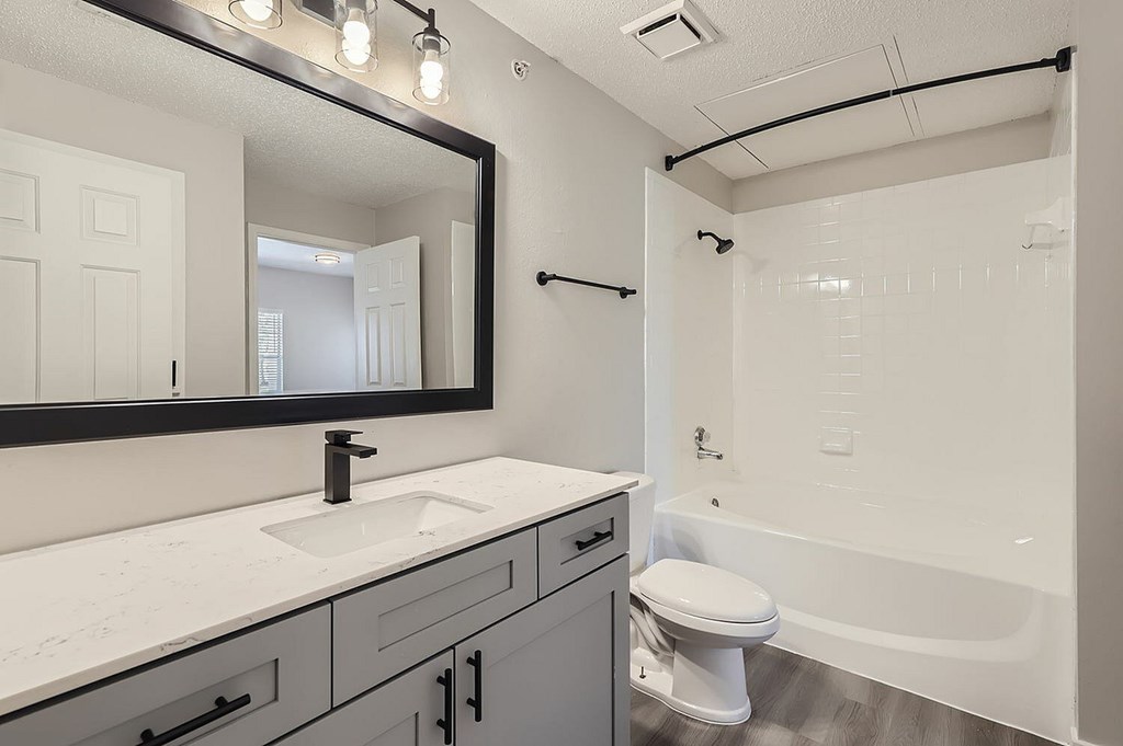 A bathroom with a white tub, sink, and toilet.