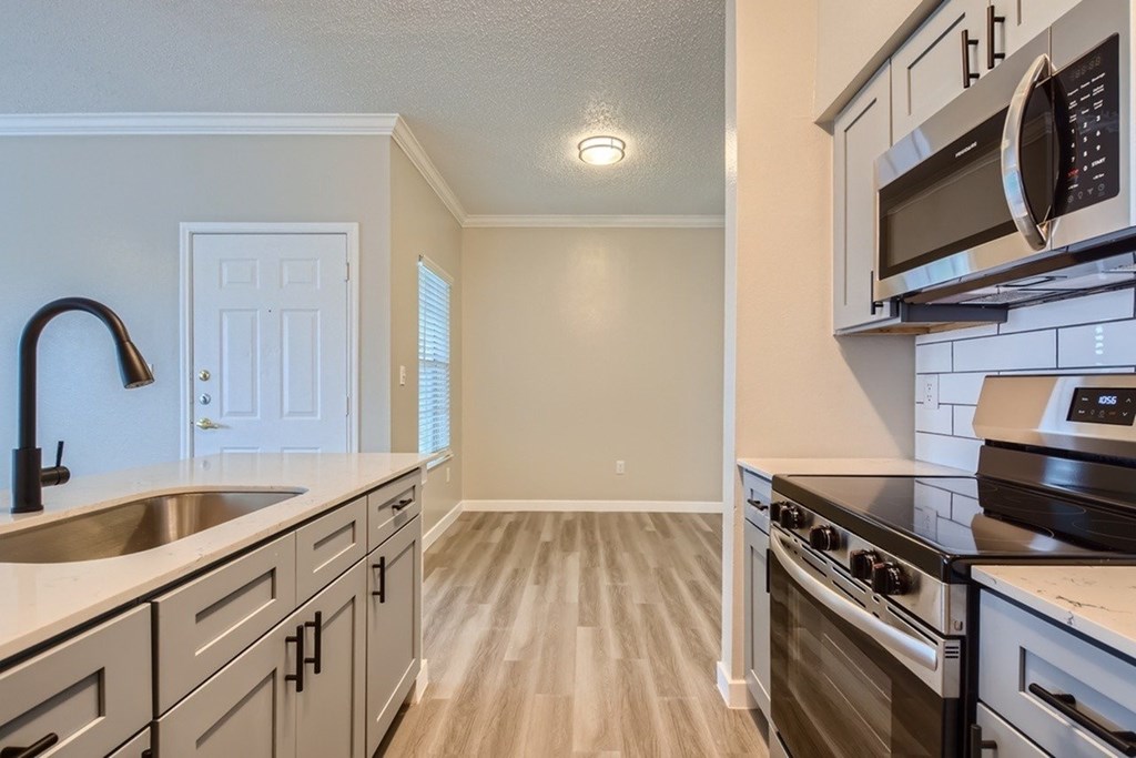 A kitchen with a stove top oven and microwave above it.