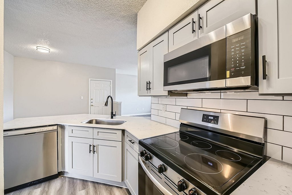 A modern kitchen with a stainless steel oven and microwave.