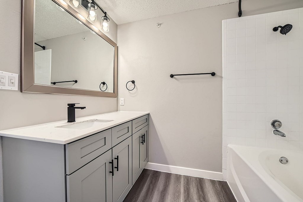 A bathroom with a white tub and a white sink.