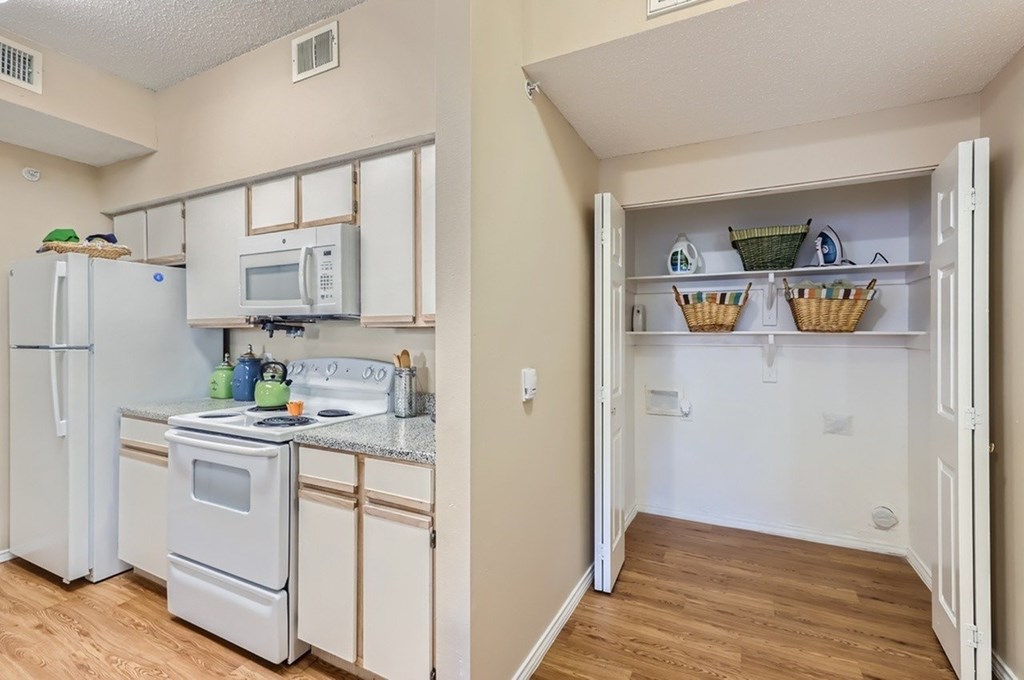 A kitchen with white appliances and a white refrigerator.
