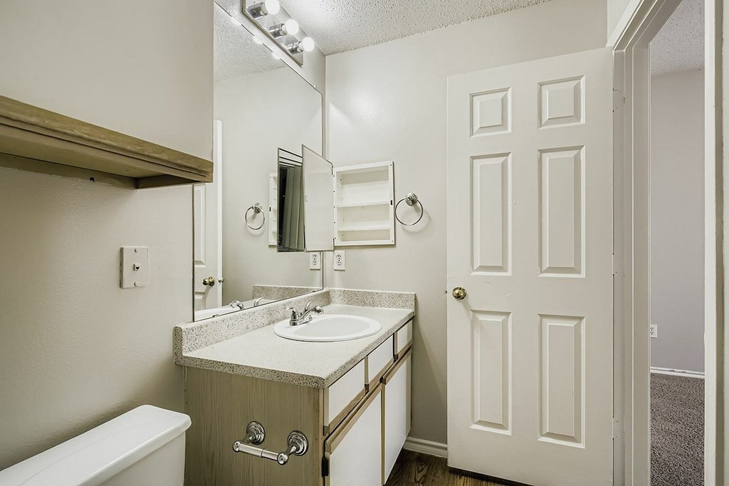 A living room with a green couch and a brown ottoman.