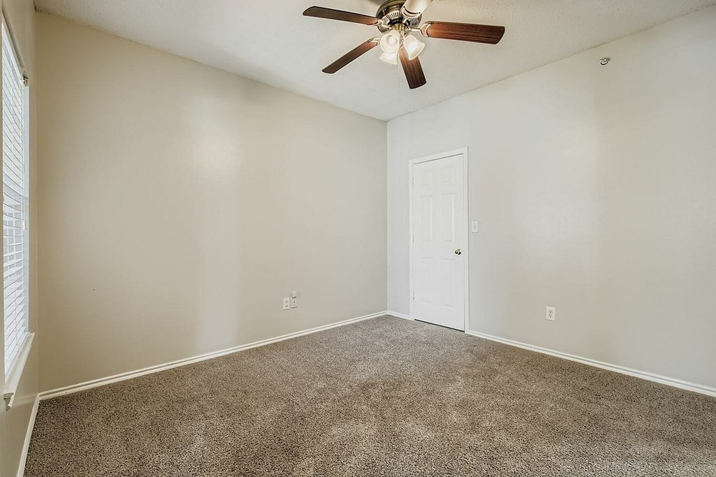 A room with a desk, chairs, and a computer.