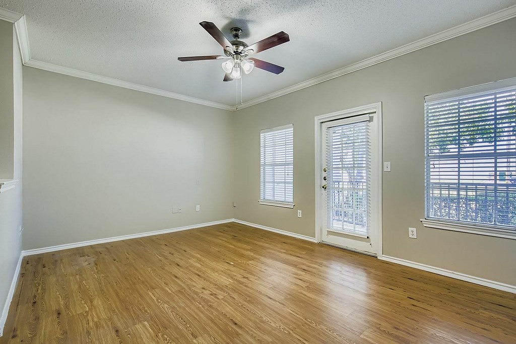 A white car is parked in a parking lot in front of a building.