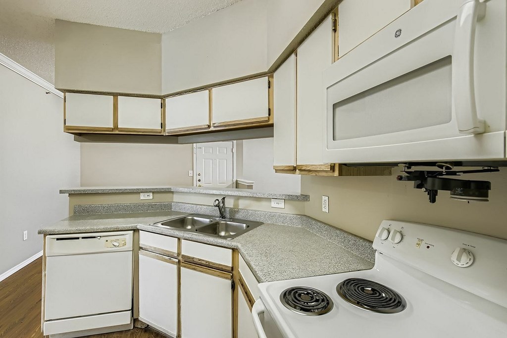 A kitchen with white appliances and a granite countertop.