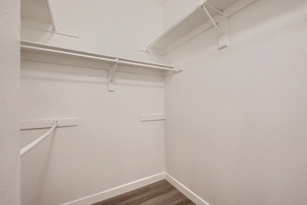 A white wall with a white shelf and a white floor.