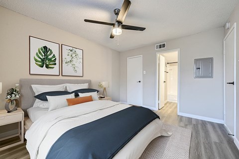 A bedroom with a large bed and a ceiling fan.