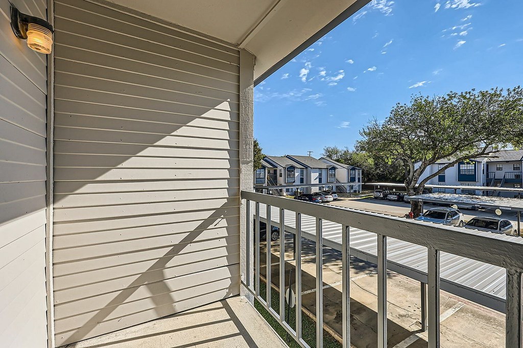 A balcony with a metal railing and a wall with horizontal siding.