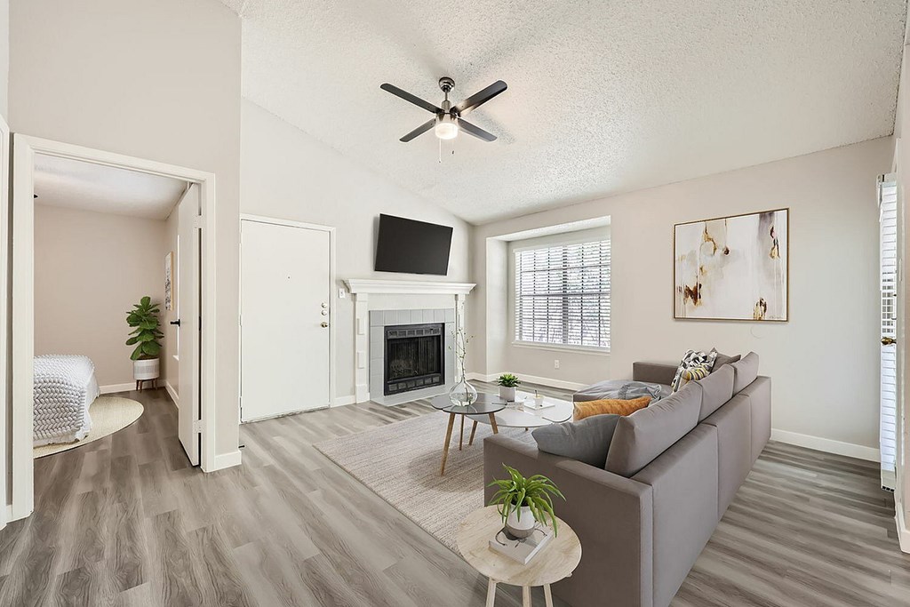 A living room with a grey couch, a white table, and a fireplace.