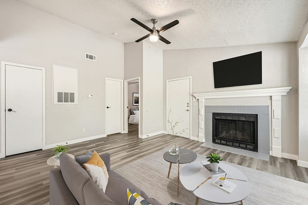 A living room with a grey couch, a white coffee table, and a fireplace.