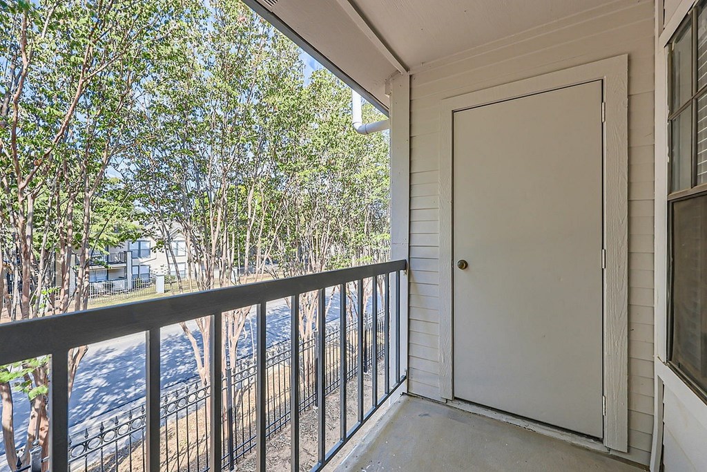 A white door is on the right side of a balcony.