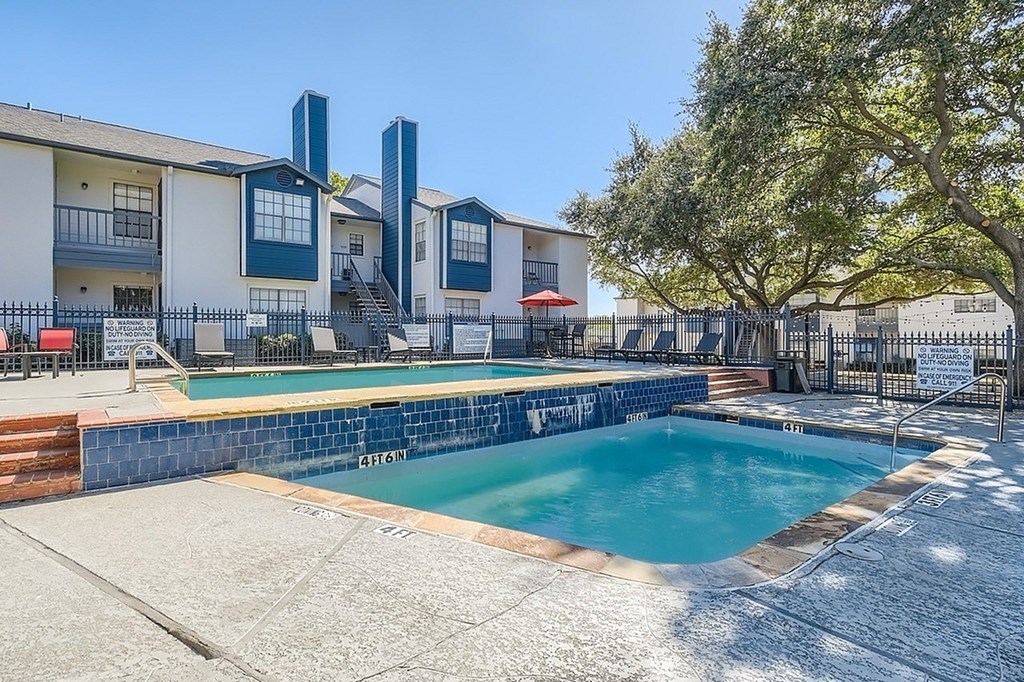 A swimming pool in front of a building with a sign that says "REFRESH".