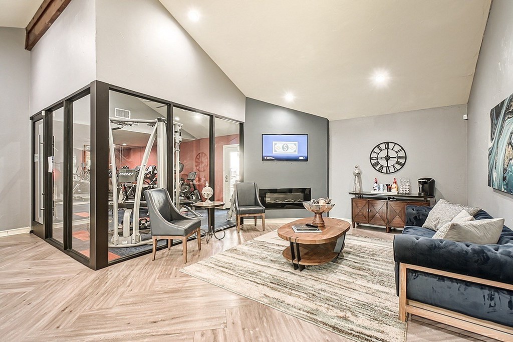 A modern living room with a black couch and a TV on the wall.