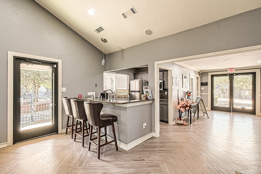 A kitchen with a bar area and a dining table with chairs.