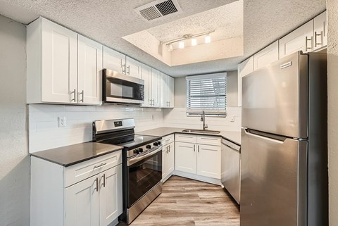 A kitchen with white cabinets and stainless steel appliances.