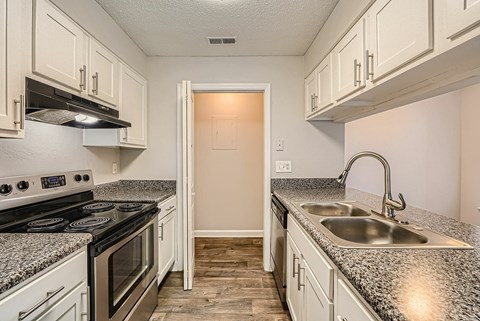 A kitchen area with a bar counter and a door leading to another room.