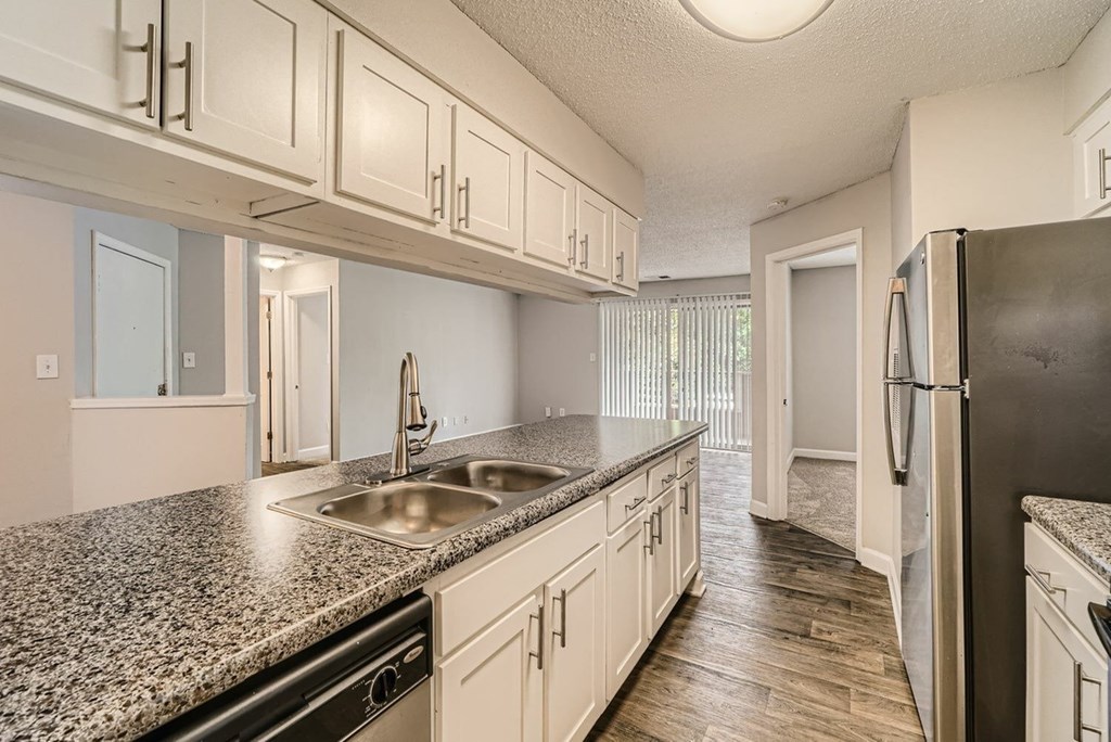 A kitchen with granite countertops and white cabinets.