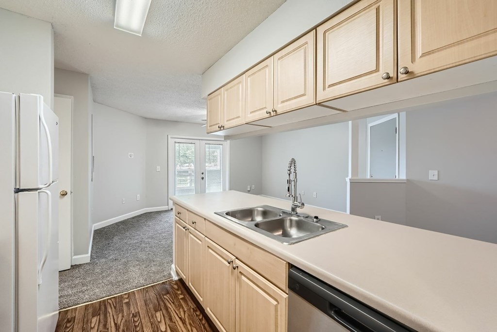 A kitchen with wooden cabinets and a white fridge.