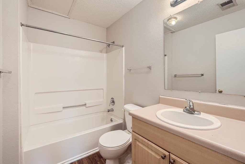 A white bathroom with a toilet, sink, and bathtub.