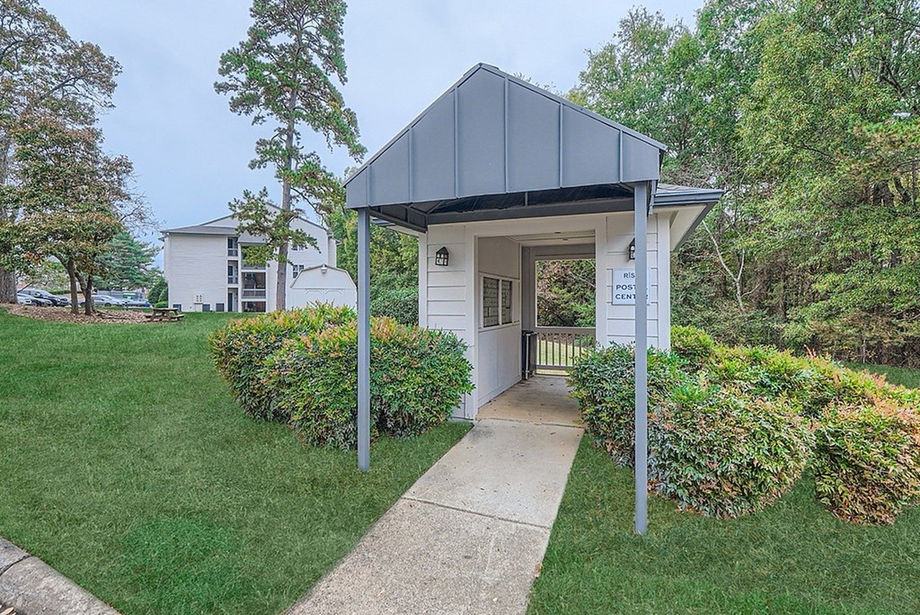A small building with a white sign in front of it.