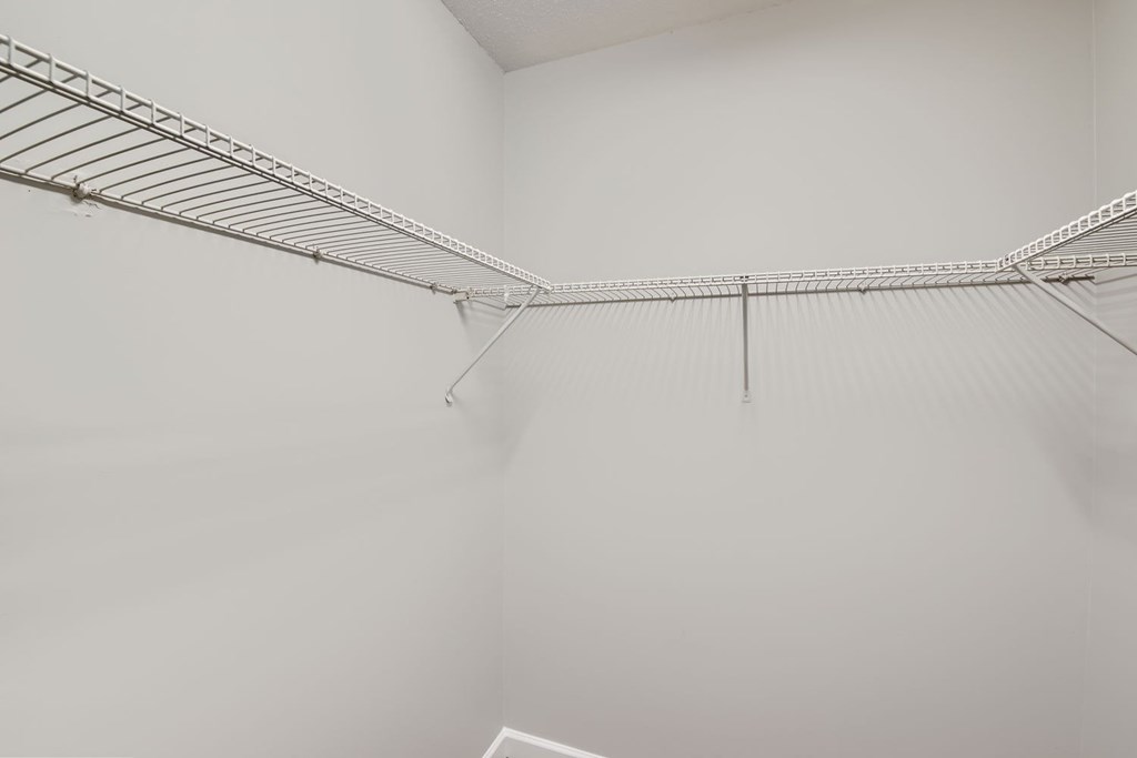 Empty silver shelving in a white room.