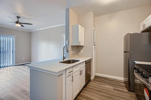 A kitchen with a sink, stove, and refrigerator.