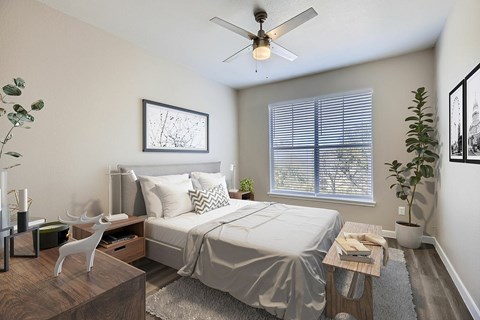 A bedroom with a bed, nightstand, and a plant.