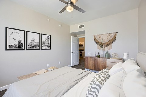 A bedroom with a bed, a dresser, and three pictures on the wall.