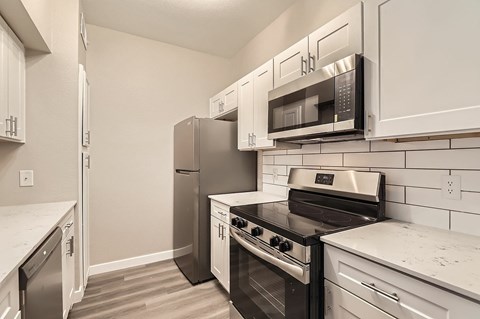 A kitchen with black appliances and white cabinets.
