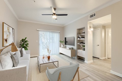 A living room with a white couch, a coffee table, and a ceiling fan.