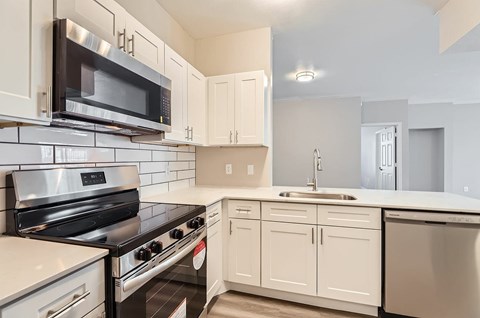 A kitchen with white cabinets and a black stove top oven.