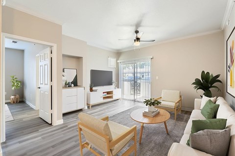 A living room with a white couch, a wooden coffee table, and a ceiling fan.