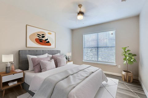 A bedroom with a large bed and a painting above it.