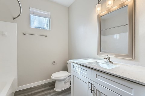 A white toilet sits in a bathroom next to a sink.