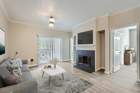 A living room with a grey couch, a white coffee table, and a fireplace.