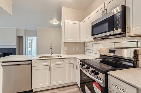 A kitchen with white cabinets and a black stove top oven.