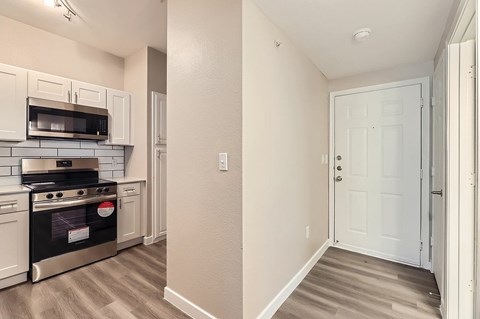 A kitchen with a black stove top oven and a white door.