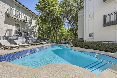 A swimming pool surrounded by a fence and trees.