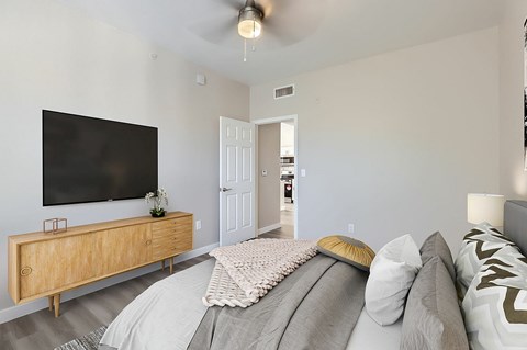A bedroom with a bed, a dresser, and a television.