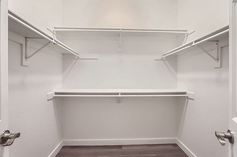 A white closet with shelves and doors.