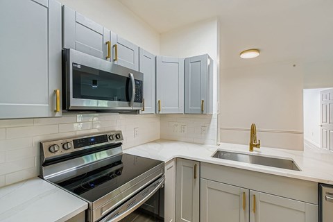 A modern kitchen with a stainless steel oven and microwave.